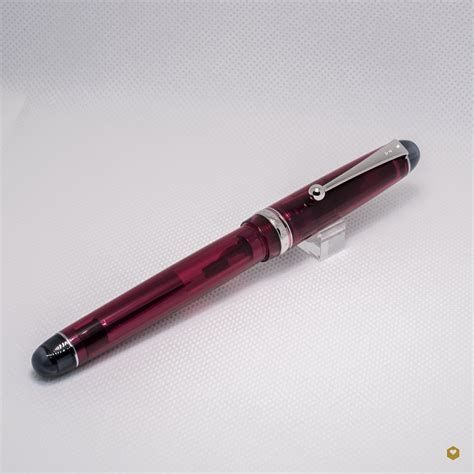 a transparent red plastic pen with silver trim and black rounded ends