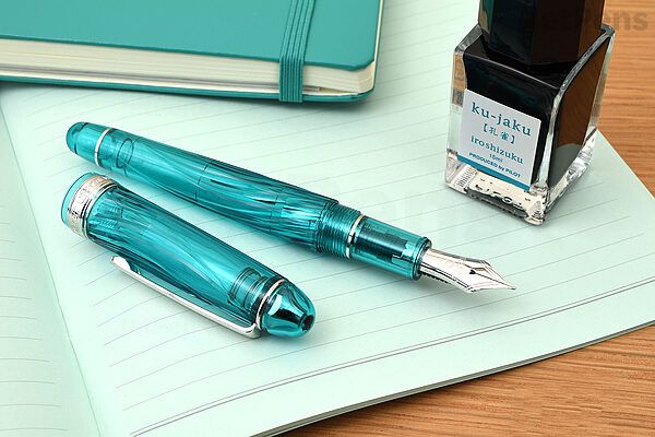 a transparent turquoise fountain pen with a swirling texture and silver trim
